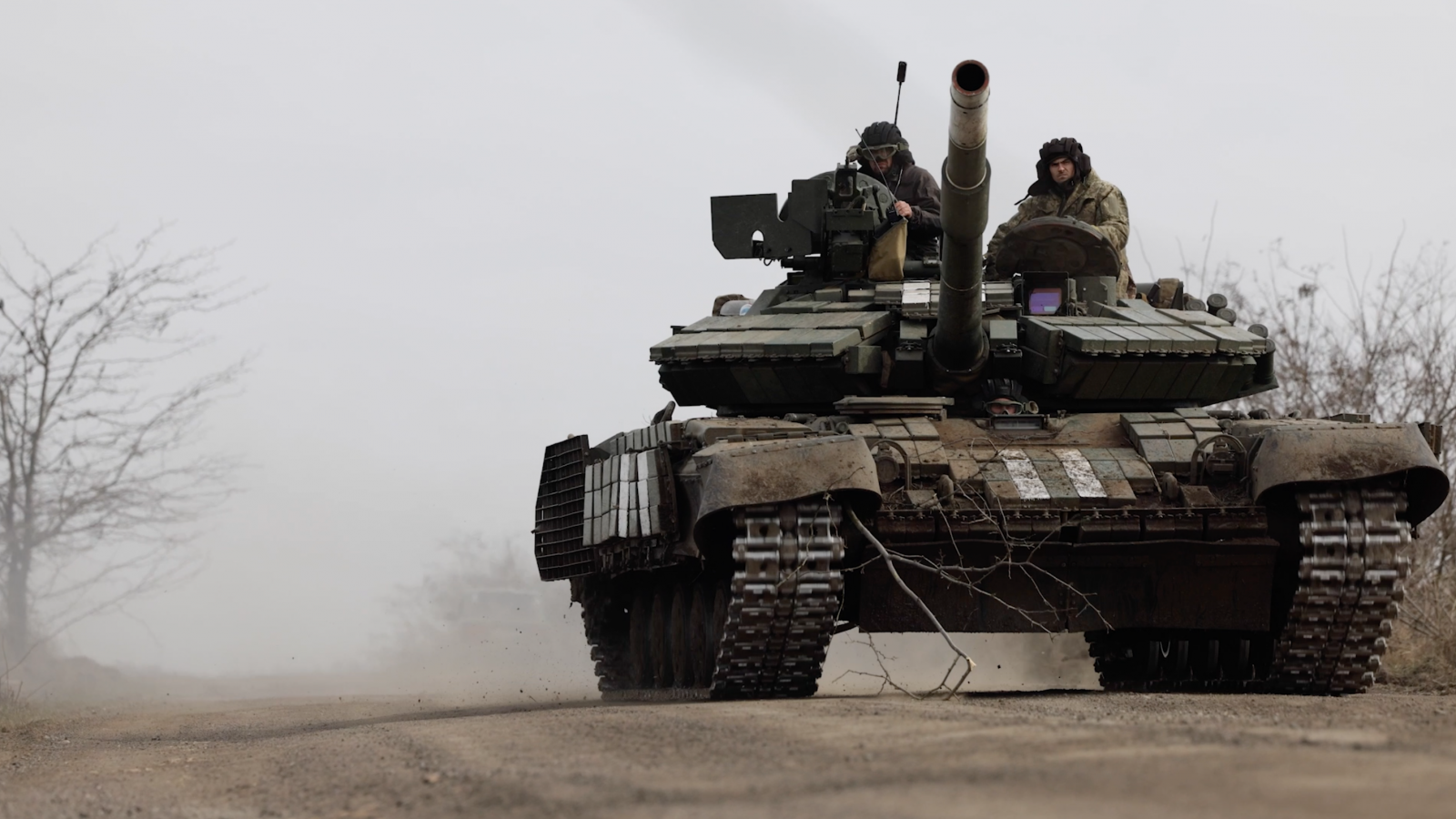 eng: Two men are riding a tank.