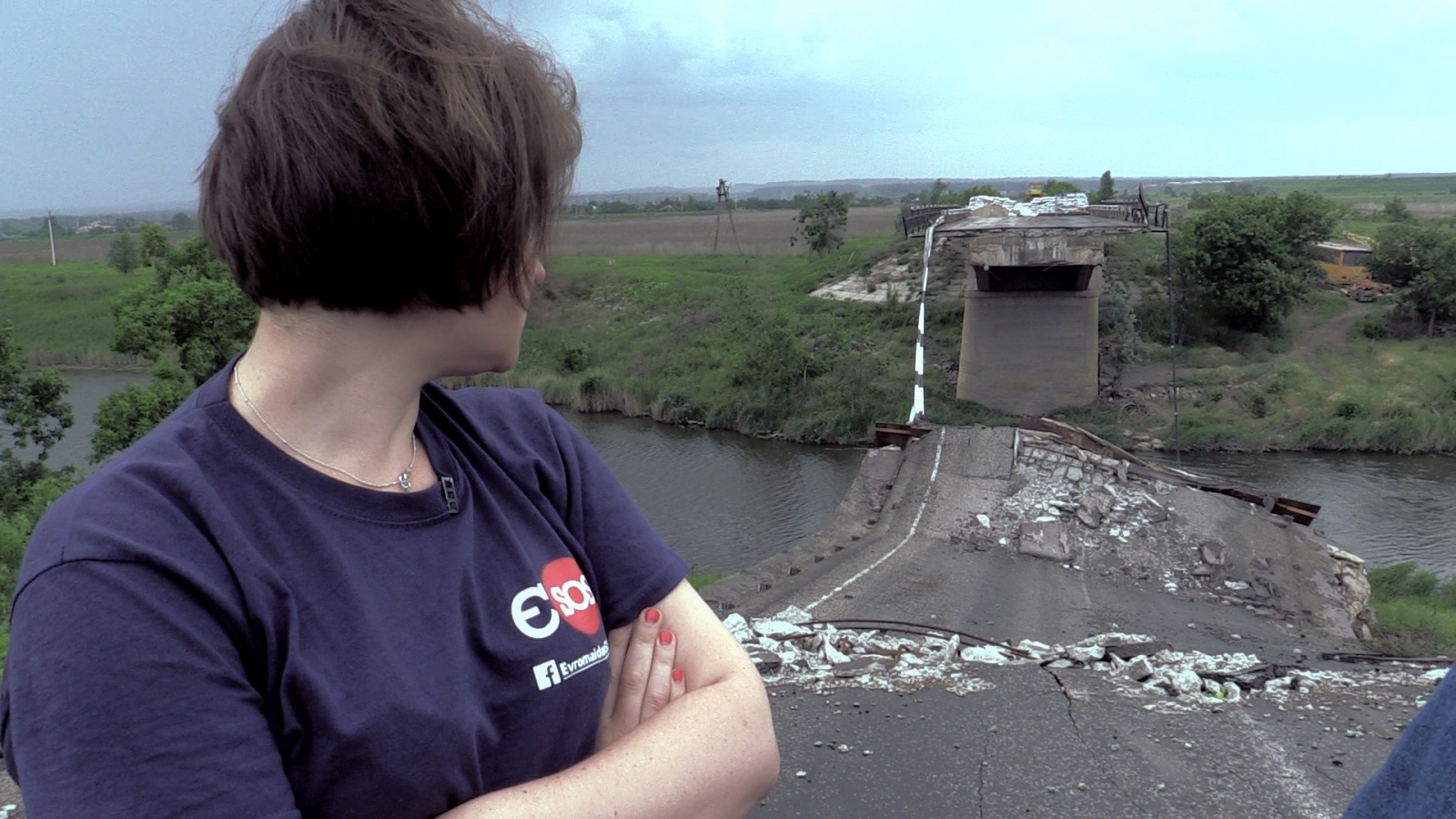 eng: The young woman looks at the destroyed bridge.